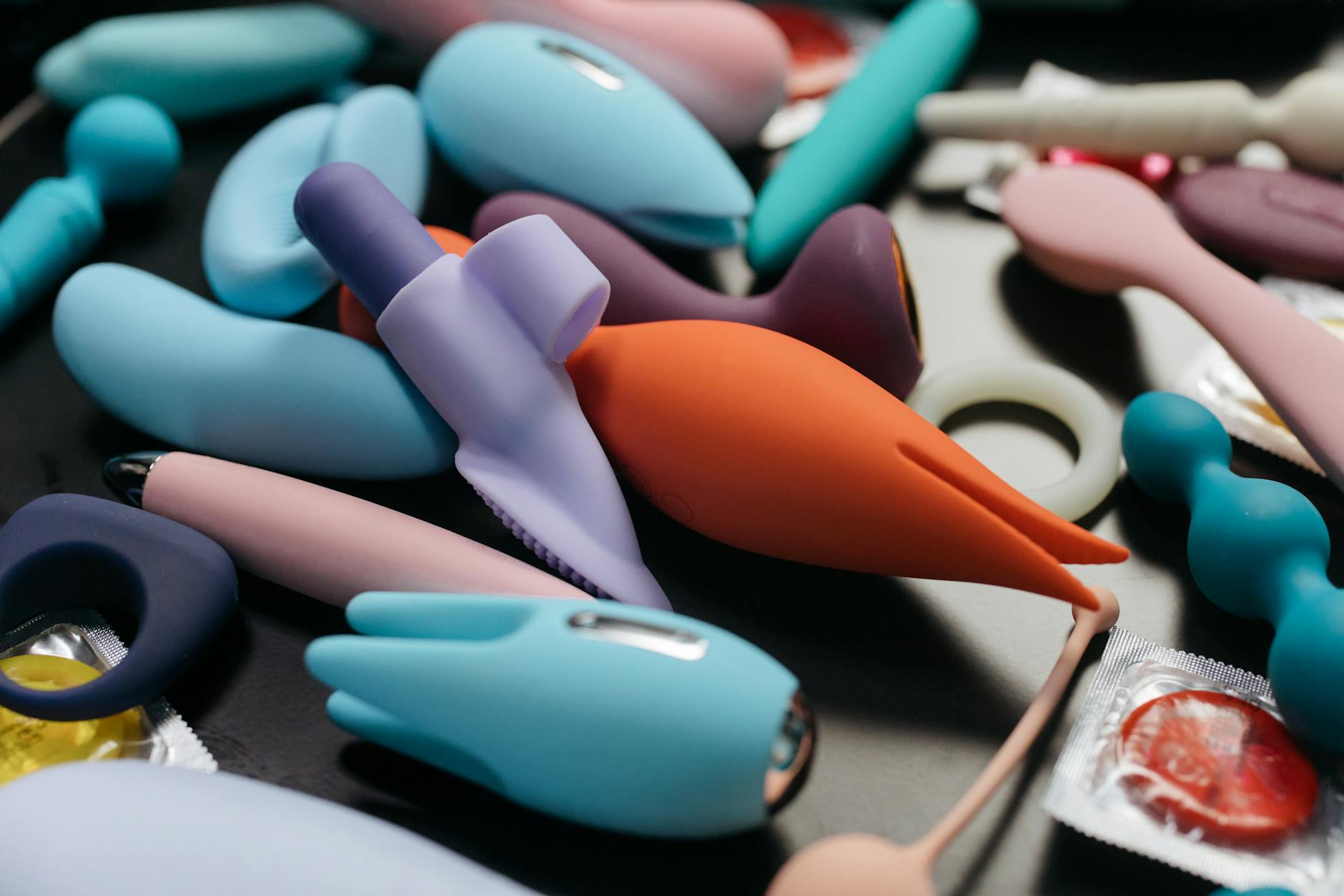 An array of vibrant clitoral vibrators in various colors displayed close-up