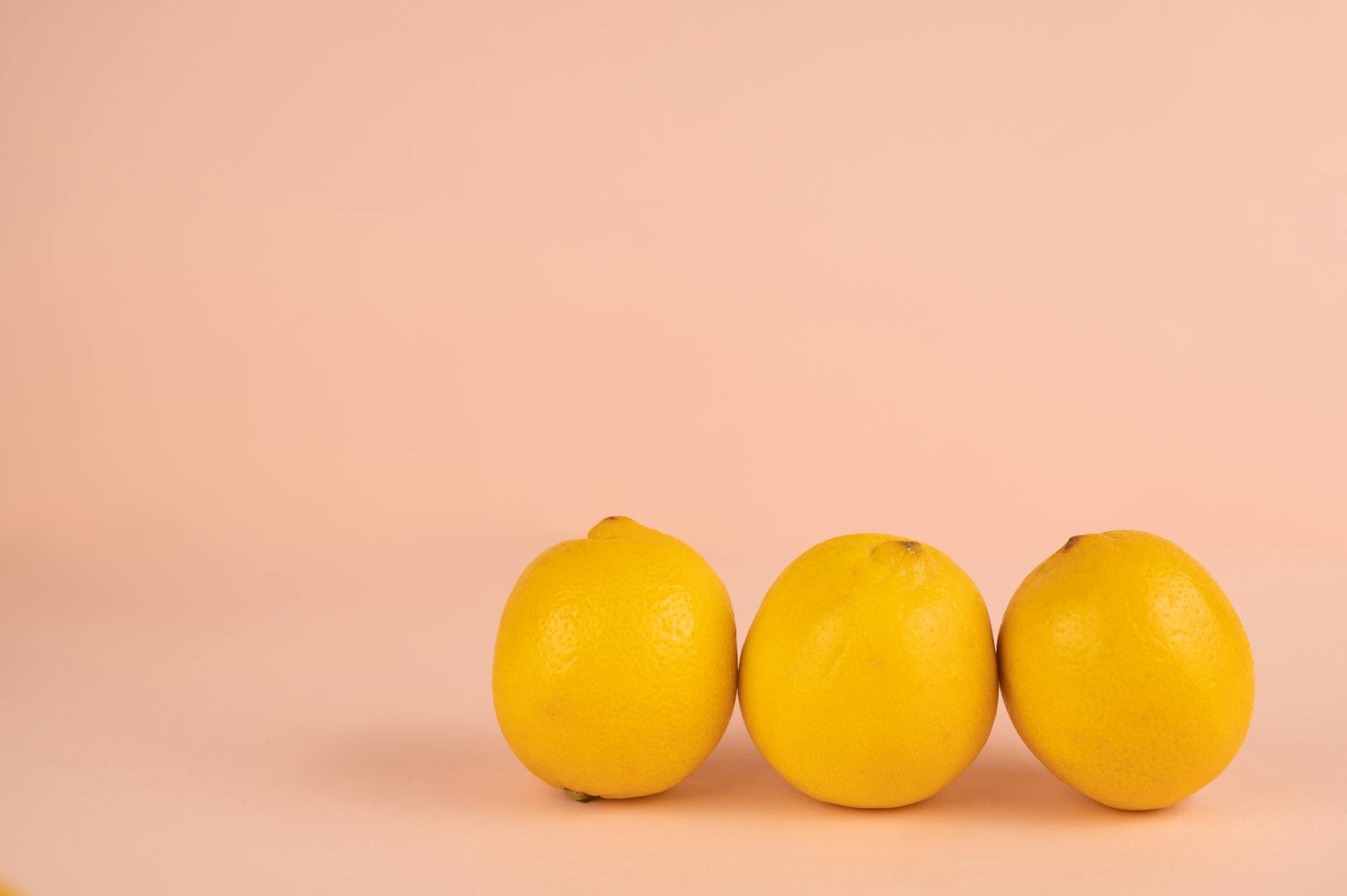 Bright ripe lemons on pastel background symbolizing fresh pleasure and vitality